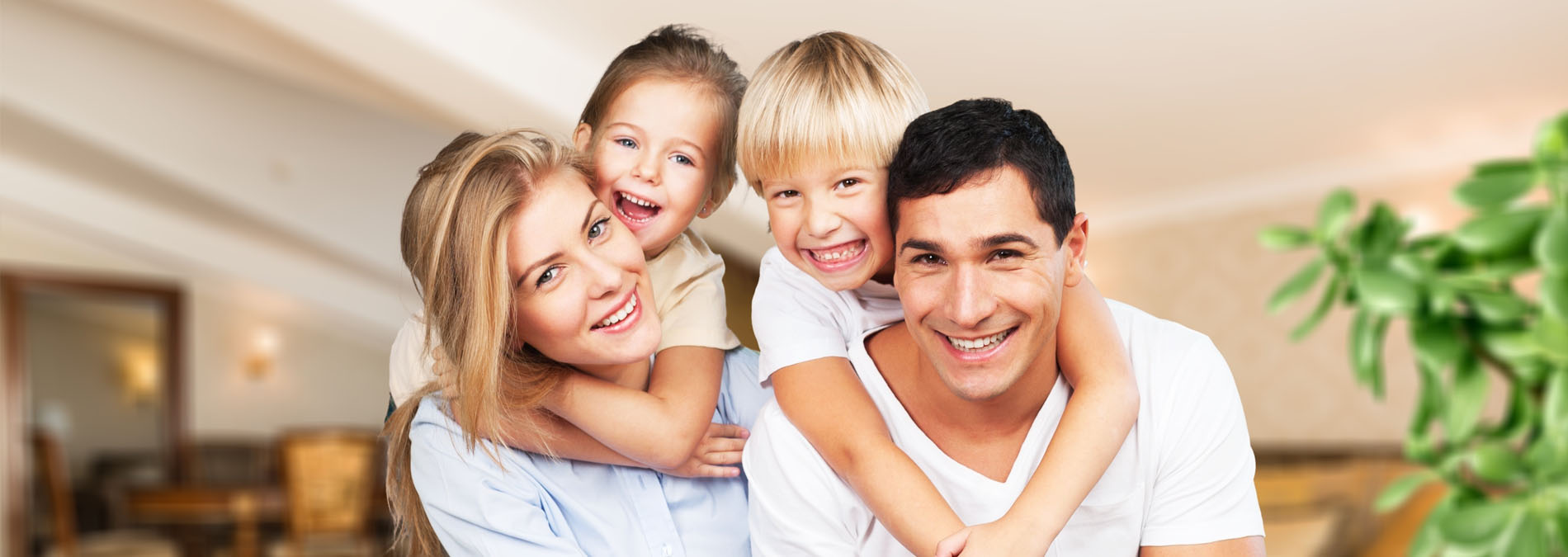 A family of four posing for a photo with a warm smile, set against a backdrop of a restaurant interior.