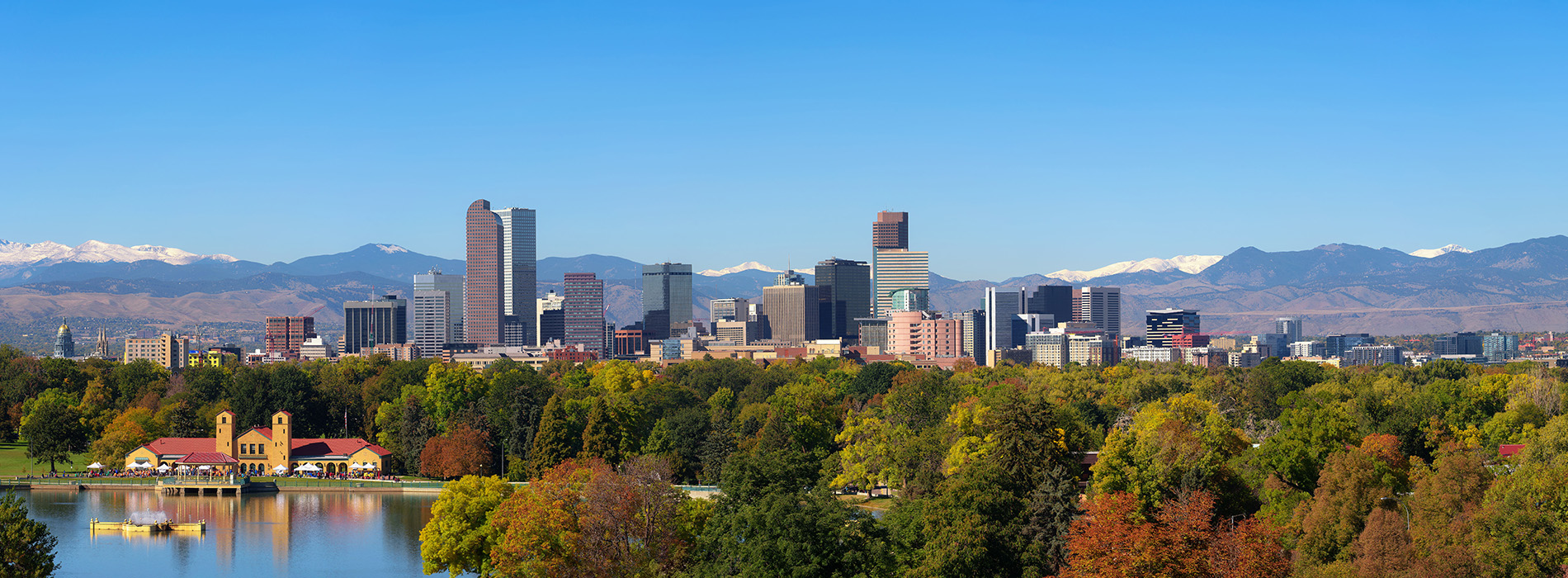 An alt text description A scenic view of a city skyline with mountains in the background under a clear blue sky.