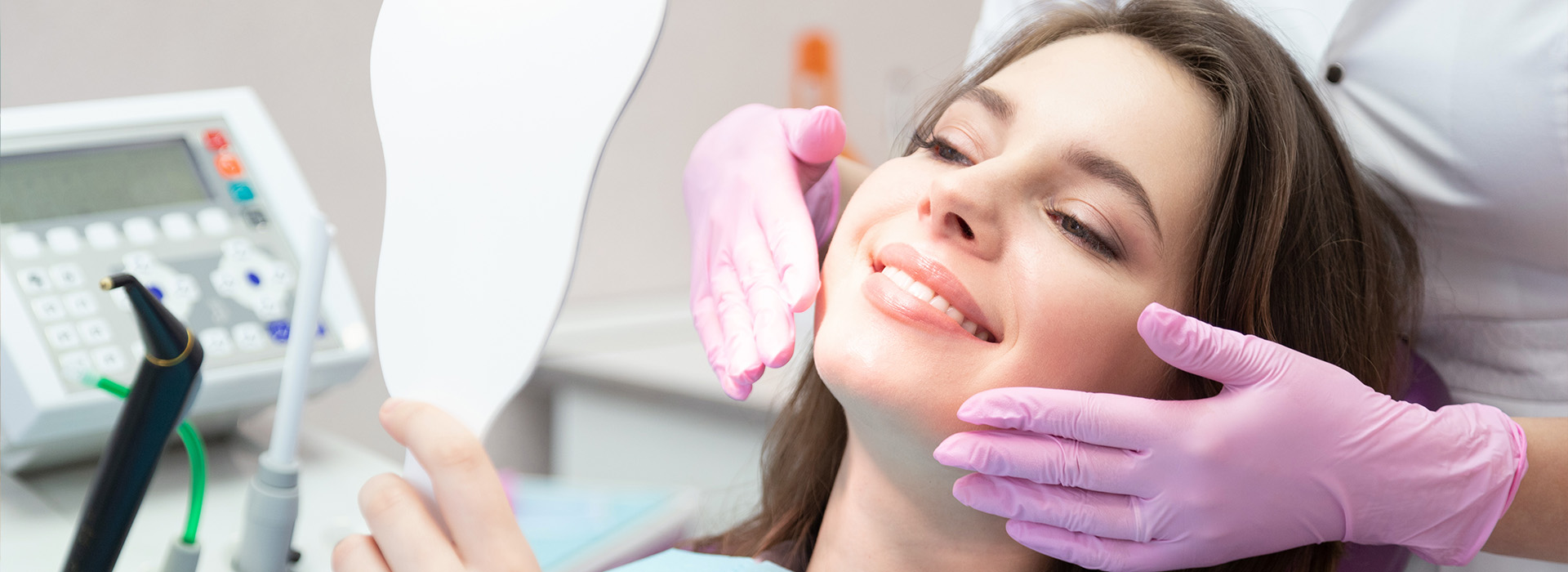 A woman receiving dental treatment under bright lights in a dental office.
