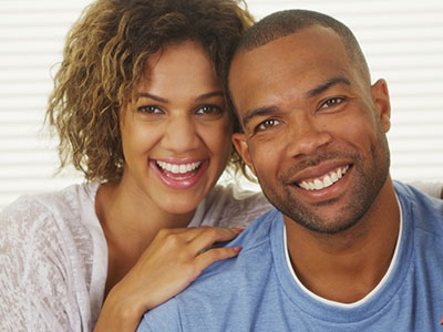 The image features a man and a woman posing together with smiles on their faces, both appearing happy and content.