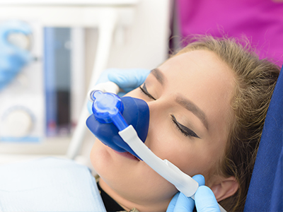 Woman receiving oxygen therapy through a nasal cannula while lying on a hospital bed.